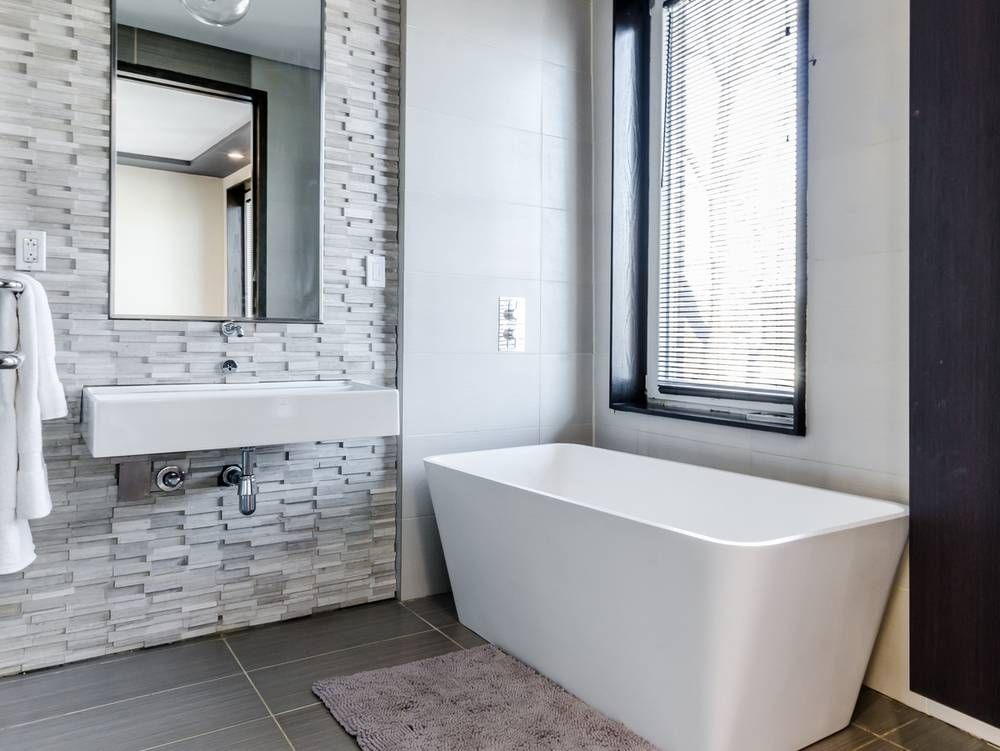 Modern bathroom with dry stack brick and white tub