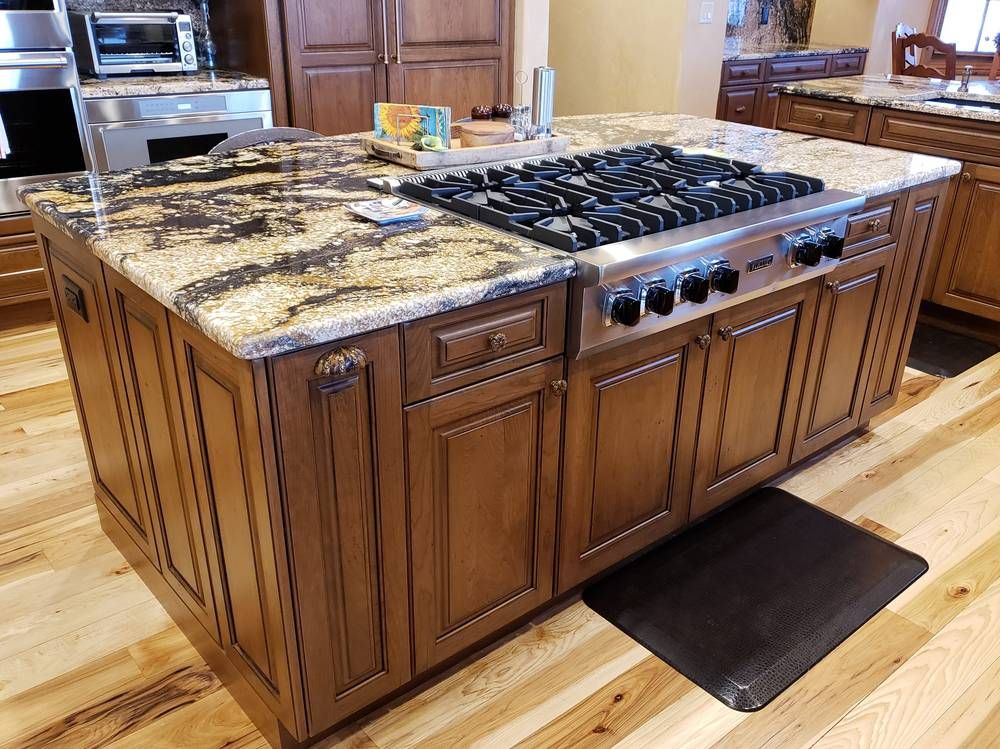 Large silver stovetop on stone countertop
